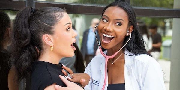 FIU Medicine student examining friend with stethoscope