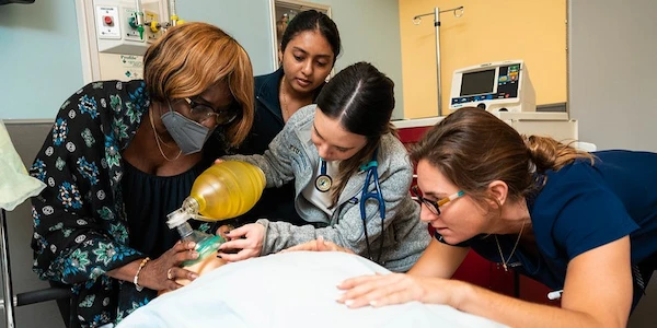 FIU Medicine professor and students examining manikin