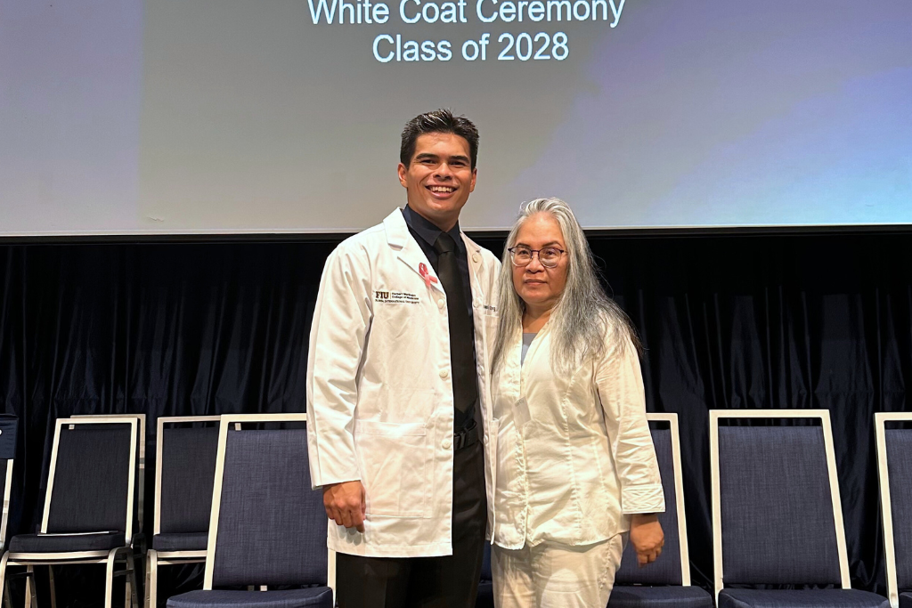Med student Thomas Kanoa King on stage at White Coat Ceremony with his mother.