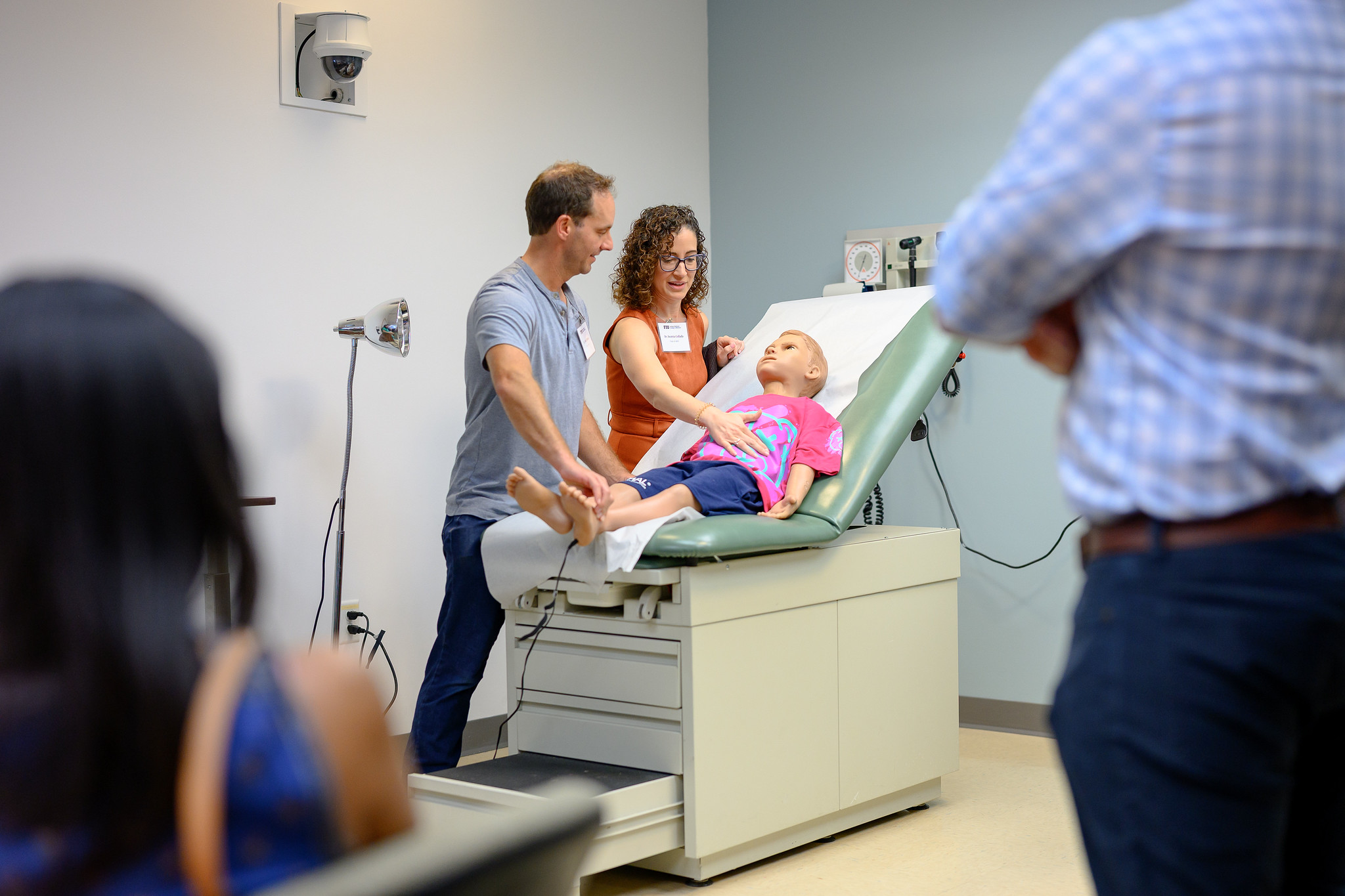 Two MD CO2016 alums interact with pediatric simulator patient in the simulation center during their campus tour.